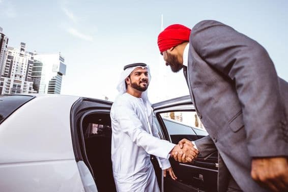 Empresário árabe-indiano discutindo planos futuros em Dubai em uma limusine.