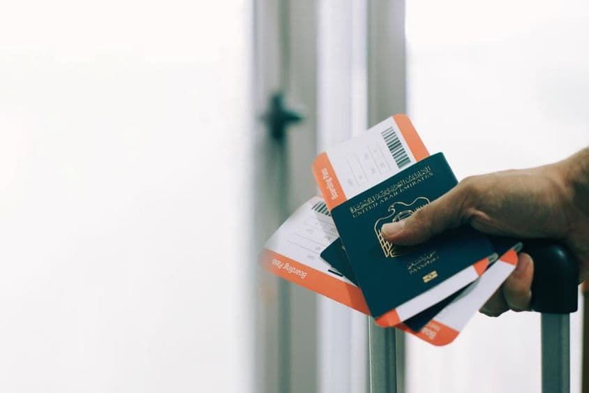 Um passageiro no aeroporto com passaporte e bilhete de voo dos EAU.