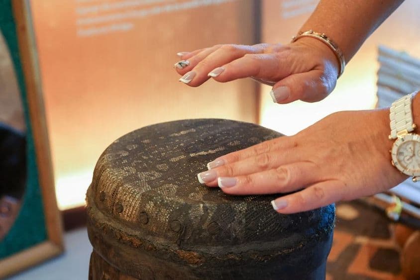 Dubai, Emirados Árabes Unidos, mulher afrodescendente tocando tambor de percussão.