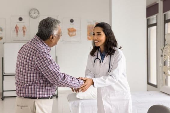 Jovem médica sorridente examinando um paciente.