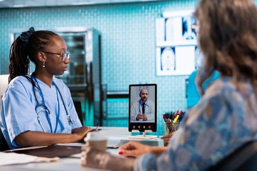 Enfermeira em videoconferência com um médico para consulta remota e telemedicina.