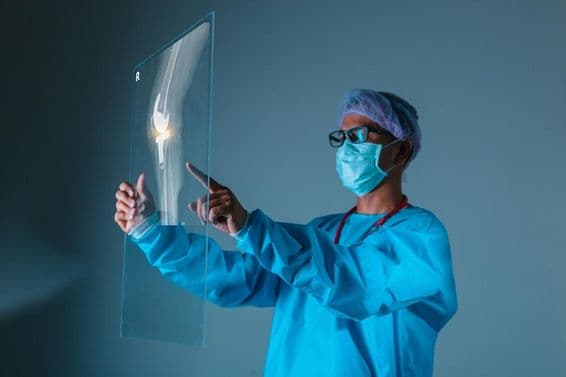 Médico segurando imagem de raio-x do osso do paciente antes da cirurgia.