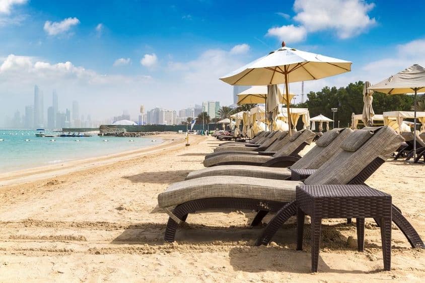 Espreguiçadeiras e guarda-sóis na praia em Abu Dhabi.