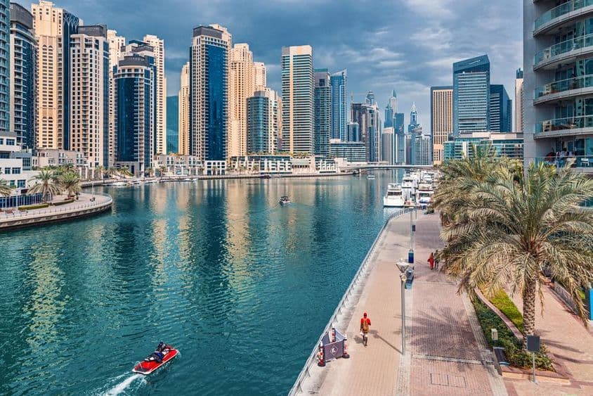 Distrito de Dubai Marina com arranha-céus e propriedades comerciais e residenciais.