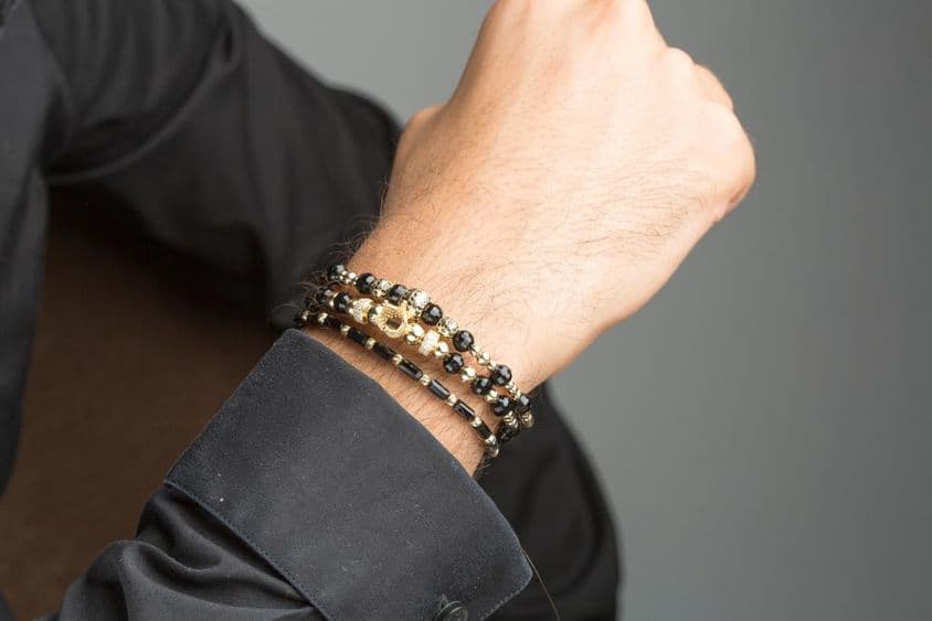 Pulseira masculina de ouro no pulso.