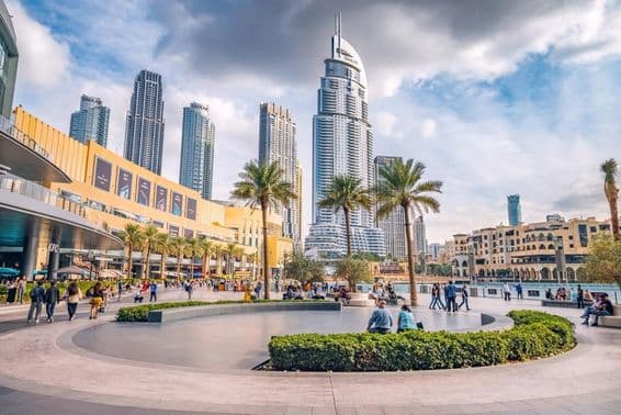 Multidões de turistas caminhando na praça e no calçadão perto da entrada do Dubai Mall.
