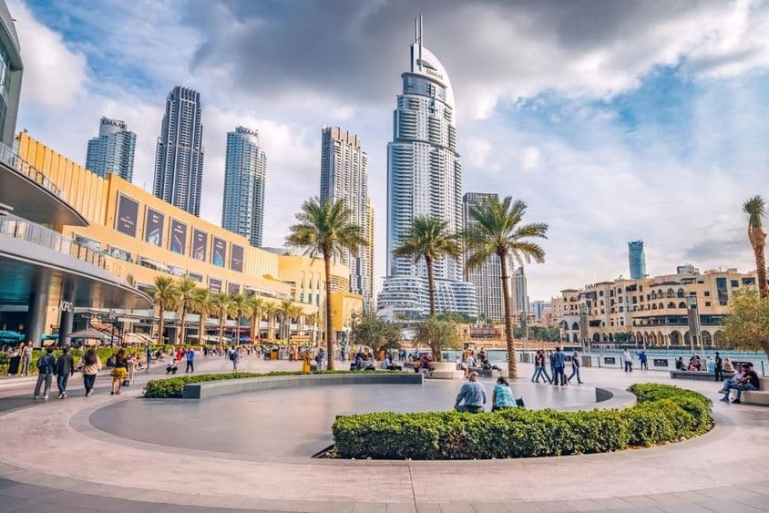 Multidões de turistas caminhando na praça e no calçadão perto da entrada do Dubai Mall.