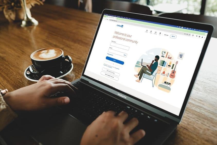 Uma pessoa abrindo a página de login do LinkedIn em um MacBook.