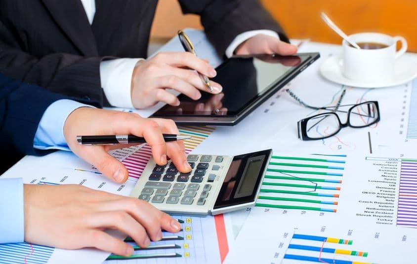 Gráficos, calculadora, tablet, mãos diligentes estudando os dados.