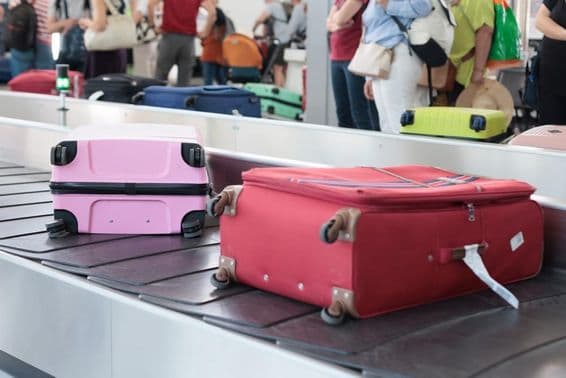 Malas em uma esteira de bagagem no aeroporto de Dubai em um dia movimentado de viagens.