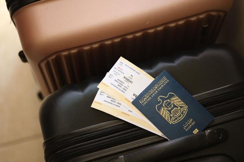 Emirados Árabes Unidos, um passaporte com passagens apoiado em uma mala.