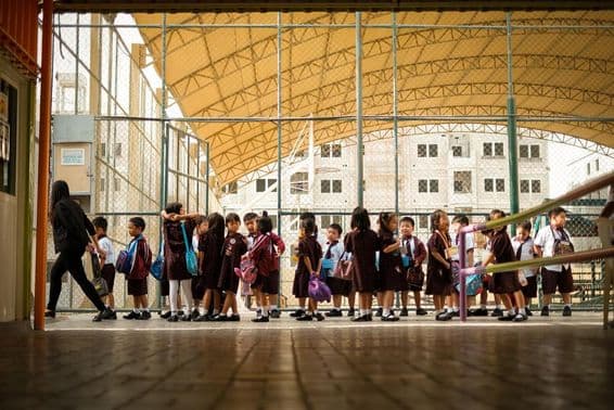 Estudantes jovens alinhados ordenadamente.