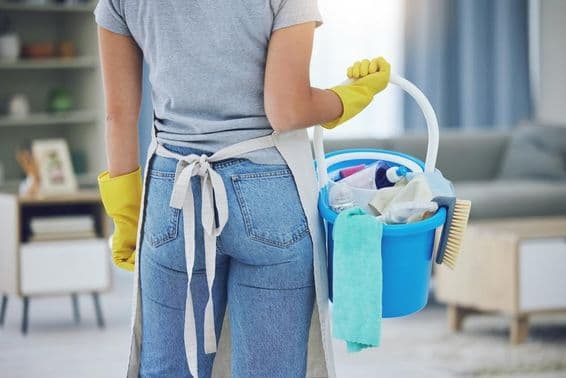Ajuda doméstica trabalhando em uma sala de estar.