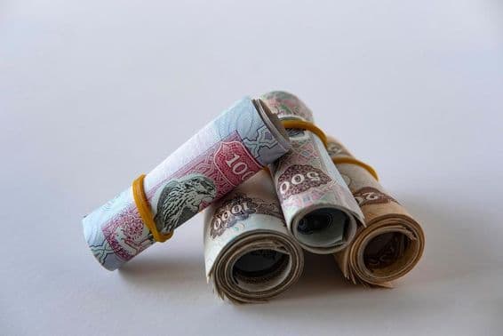 Uma coleção de moeda e moedas de dirham dos EAU enroladas e empilhadas.