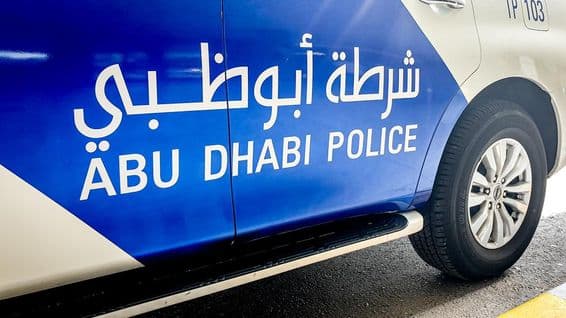 Carro policial de Abu Dhabi com escrita em inglês e árabe.