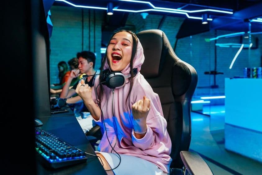 Uma bela jovem asiática jogando videogames em um café internet.