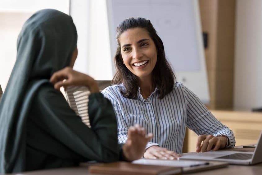 Mulher de negócios que fala espanhol conversando com colega árabe.