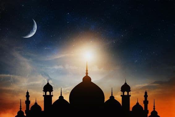 Cúpulas de mesquita contra um céu crepuscular azul profundo com uma lua crescente ao fundo.
