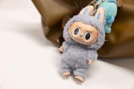Visão do famoso Popmart Labubu na bolsa de uma mulher.