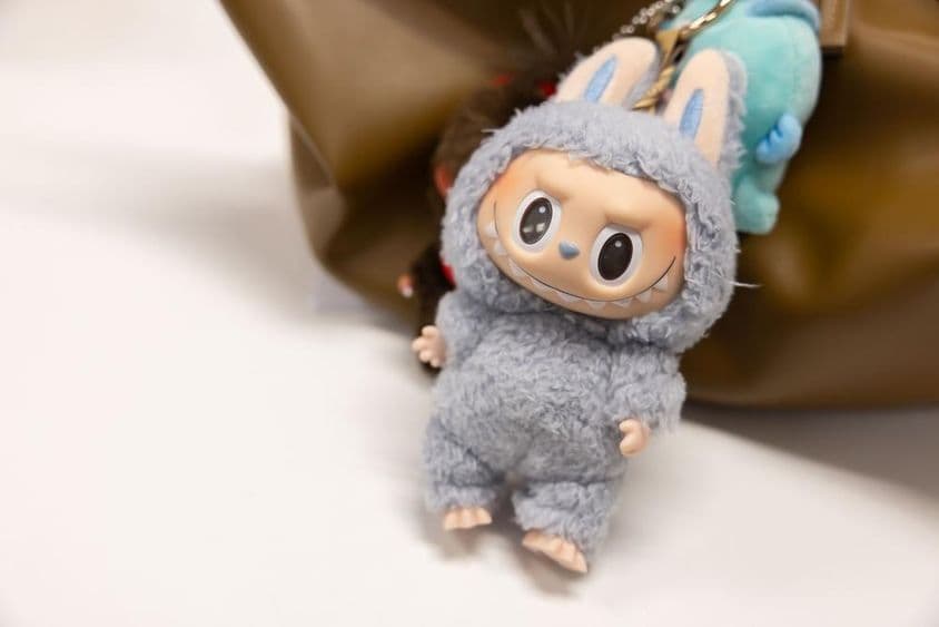 Visão do famoso Popmart Labubu na bolsa de uma mulher.