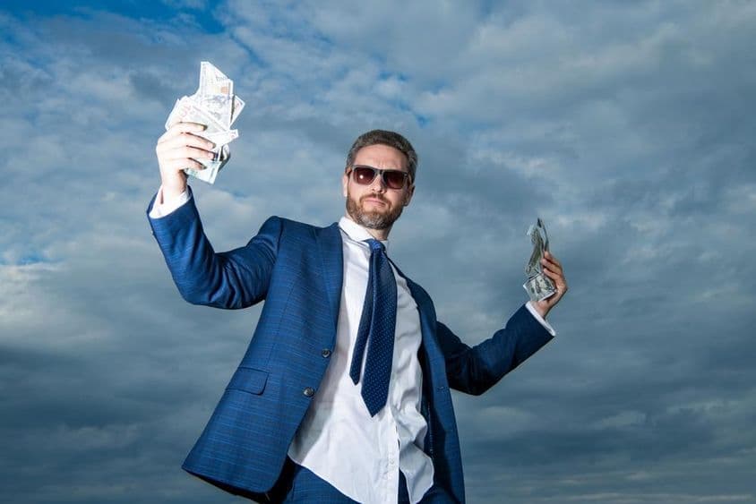 Um homem bilionário com dinheiro em um terno.