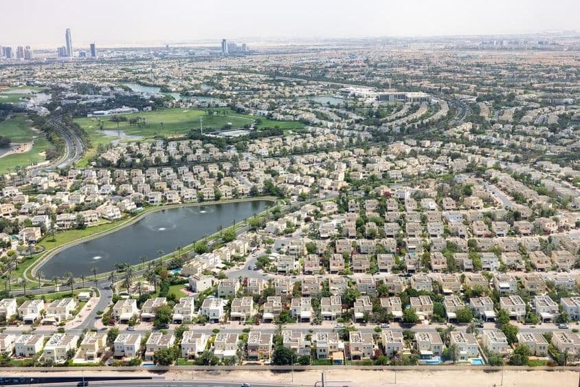 Emirates Hills Dubai com casas comunitárias, lago e áreas verdes.