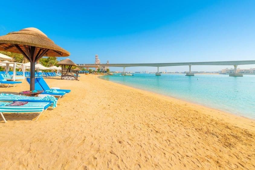 Em uma praia arenosa do Golfo Arábico, o monotrilho da Ilha Palm Jumeirah cruza o mar em Dubai.