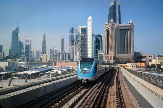 Vista de um trem de metrô entre arranha-céus em Dubai.
