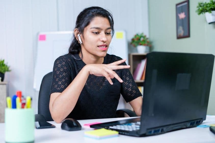 Jovem empresária indiana convencendo um cliente sobre um projeto por videochamada.