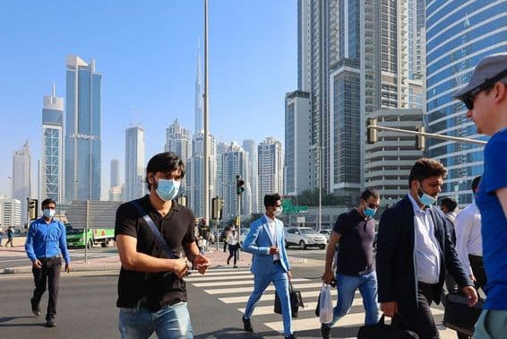 Pessoas atravessando uma faixa de pedestres no centro comercial de Dubai.