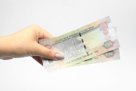 500 AED em mãos de uma mulher.