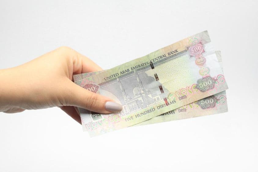 500 AED em mãos de uma mulher.
