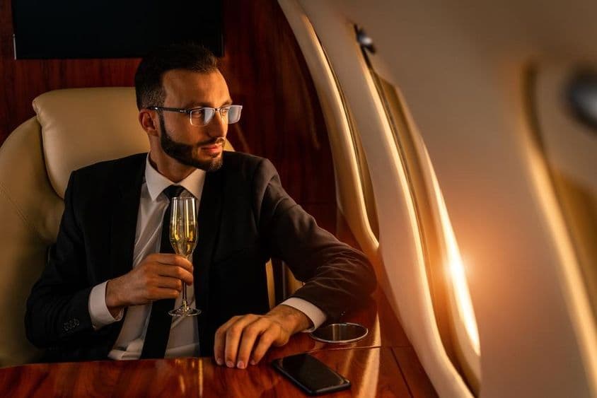 Empresário em um elegante terno, voando em um jato privado exclusivo.