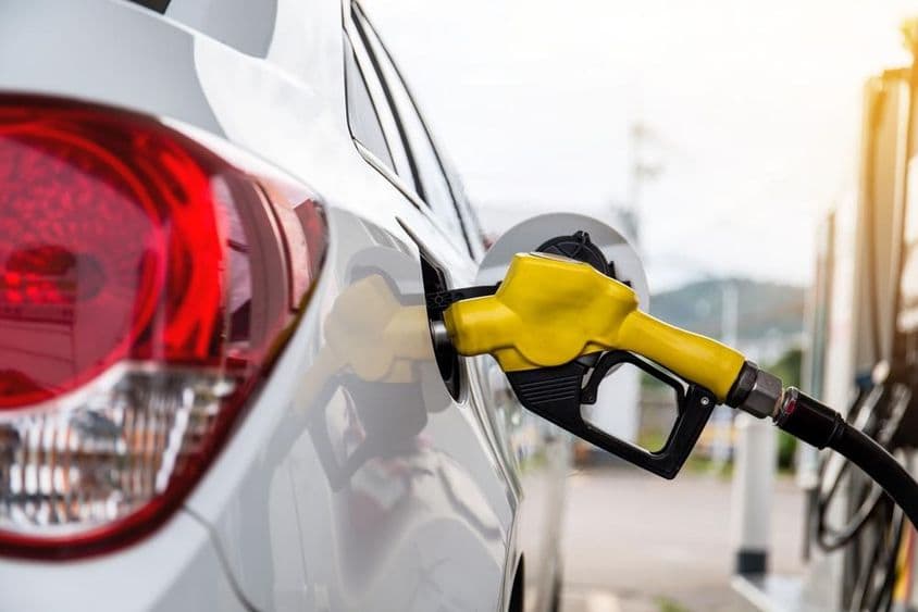 Homem em Dubai abastecendo um carro em um posto de gasolina.