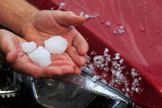 Uma pessoa segurando granizo na mão.