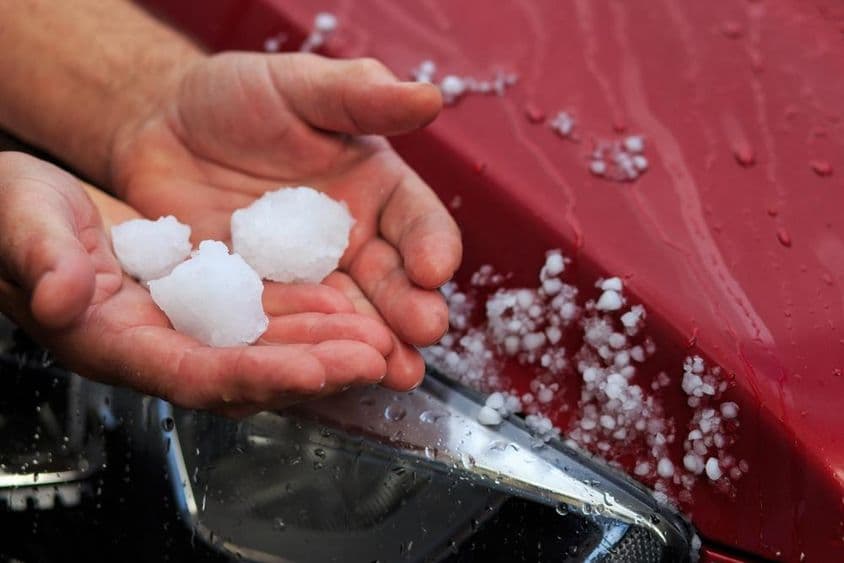 Uma pessoa segurando granizo na mão.