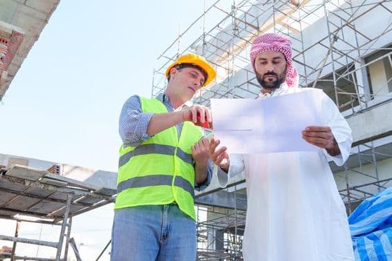 Empresário árabe examinando um plano de engenharia civil.