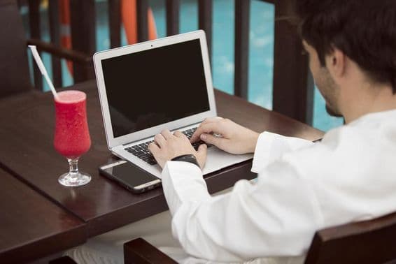 Jovem empresário árabe trabalhando com um laptop em um café.