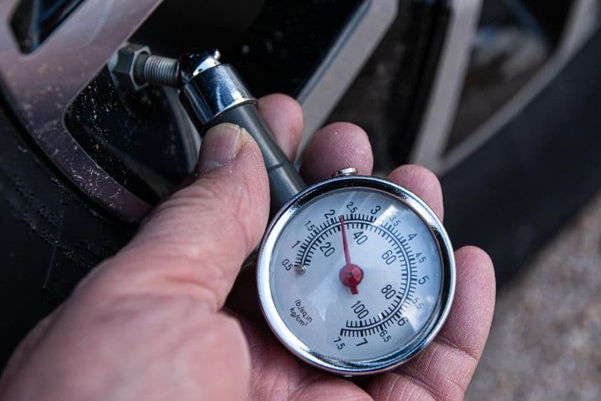 Verifique a pressão com manômetro para inflar corretamente um pneu de carro.