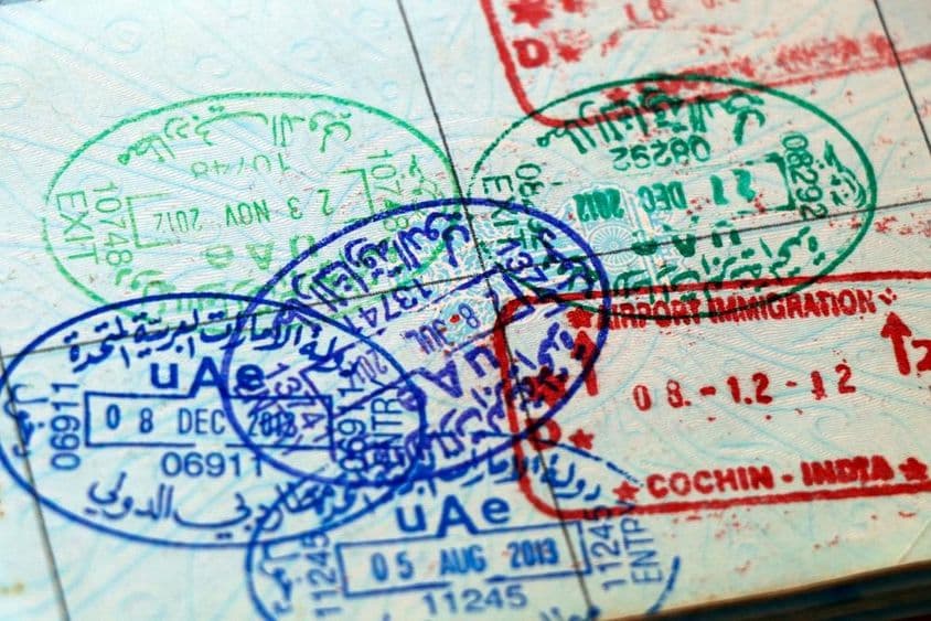Carimbos oficiais dos Emirados Árabes Unidos e da Índia em uma página de passaporte.