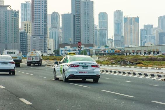 Aman táxi na estrada na cidade de Sharjah.