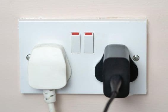 Tomada inglesa na parede com interruptores.