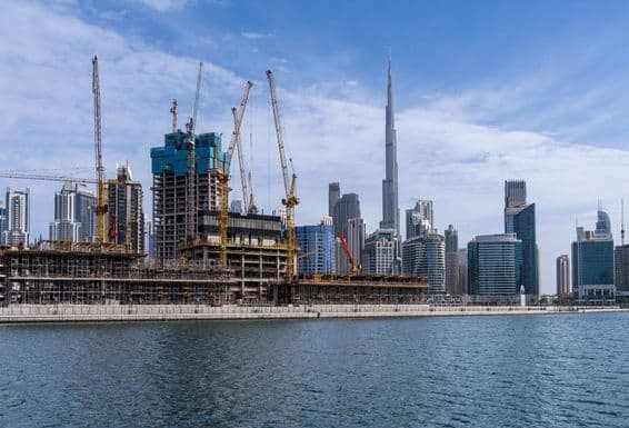 Guindastes construindo novos apartamentos na área de Business Bay em Dubai.