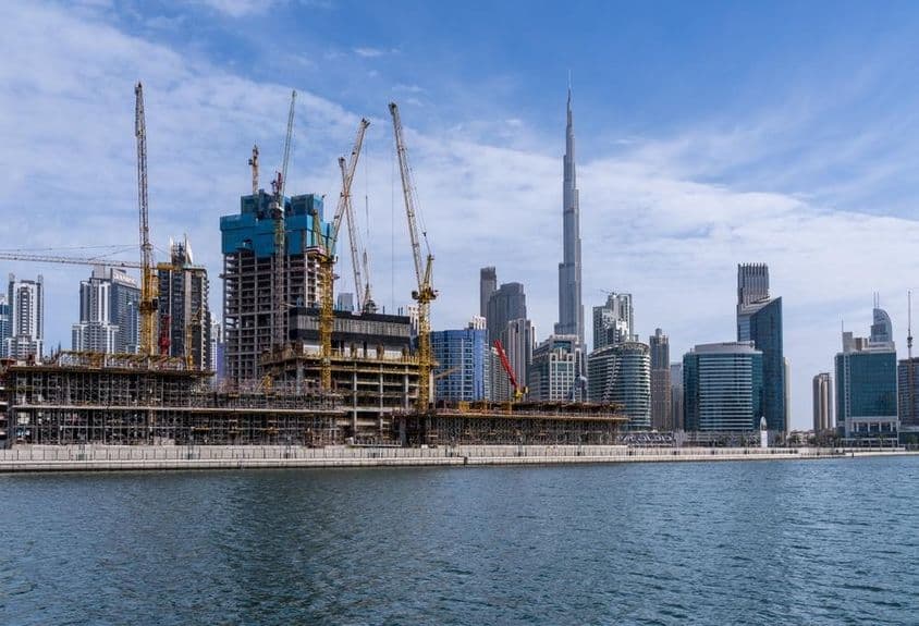 Guindastes construindo novos apartamentos na área de Business Bay em Dubai.