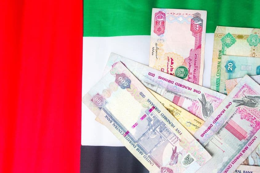 Cédulas de dirham dos EAU sobre a bandeira nacional.