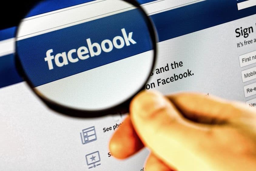 Captura de tela da página inicial do Facebook em um monitor através de uma lupa.