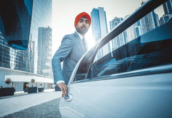 Empresário indiano com carro da empresa em Dubai.