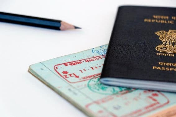 Carimbos oficiais dos Emirados Árabes Unidos e Índia em uma página de passaporte, em árabe e hindi.