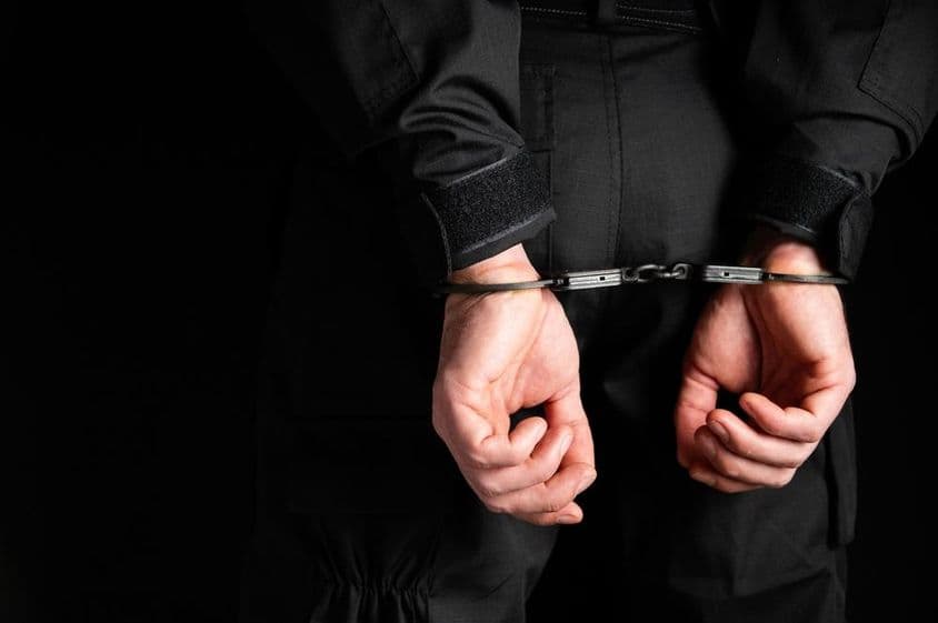 Mãos de um criminoso algemadas.