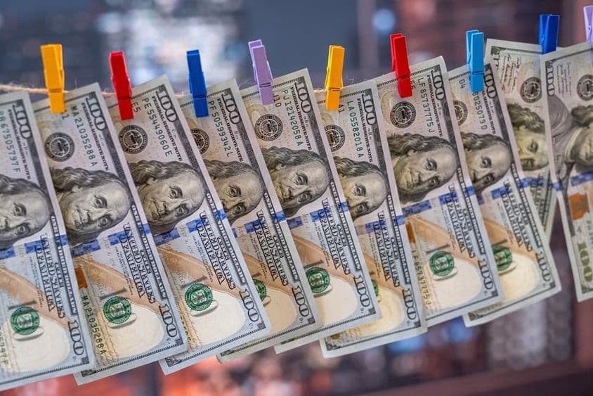 Nota de 100 dólares dos EUA pendurada em um varal com pregadores de madeira.